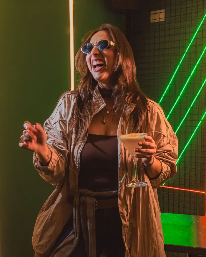 Invitada ríe con su cóctel en una noche de BKR48